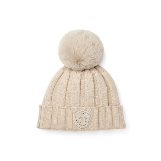A cream-colored ribbed knit beanie hat with a matching faux fur pom-pom on top and a small embroidered heart logo on the front cuff, shown against a plain white background.